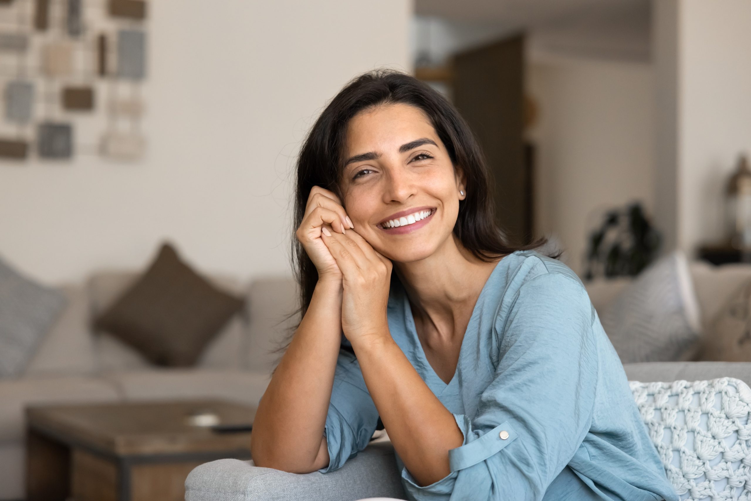 Calm woman sitting comfortably on a sofa at home