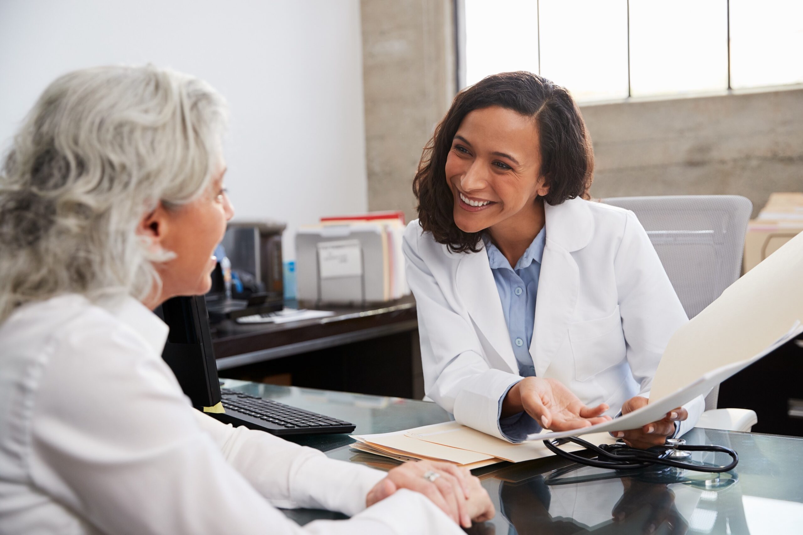 Smiling doctor in consultation with a senior patient