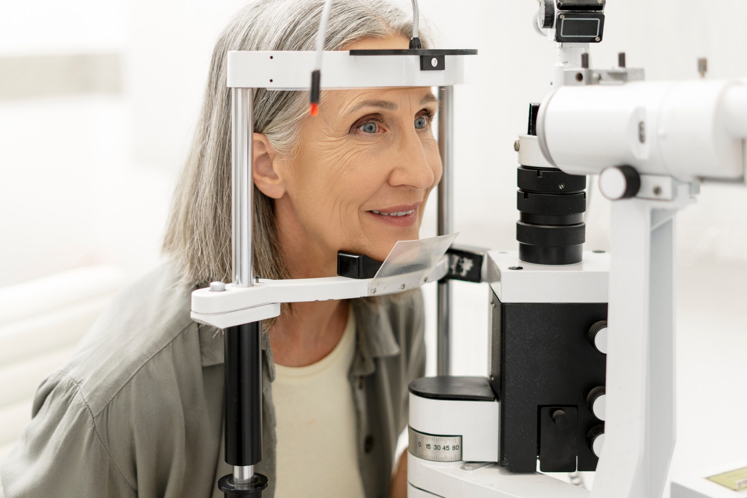 Smiling senior woman having an eye exam with a phoropter