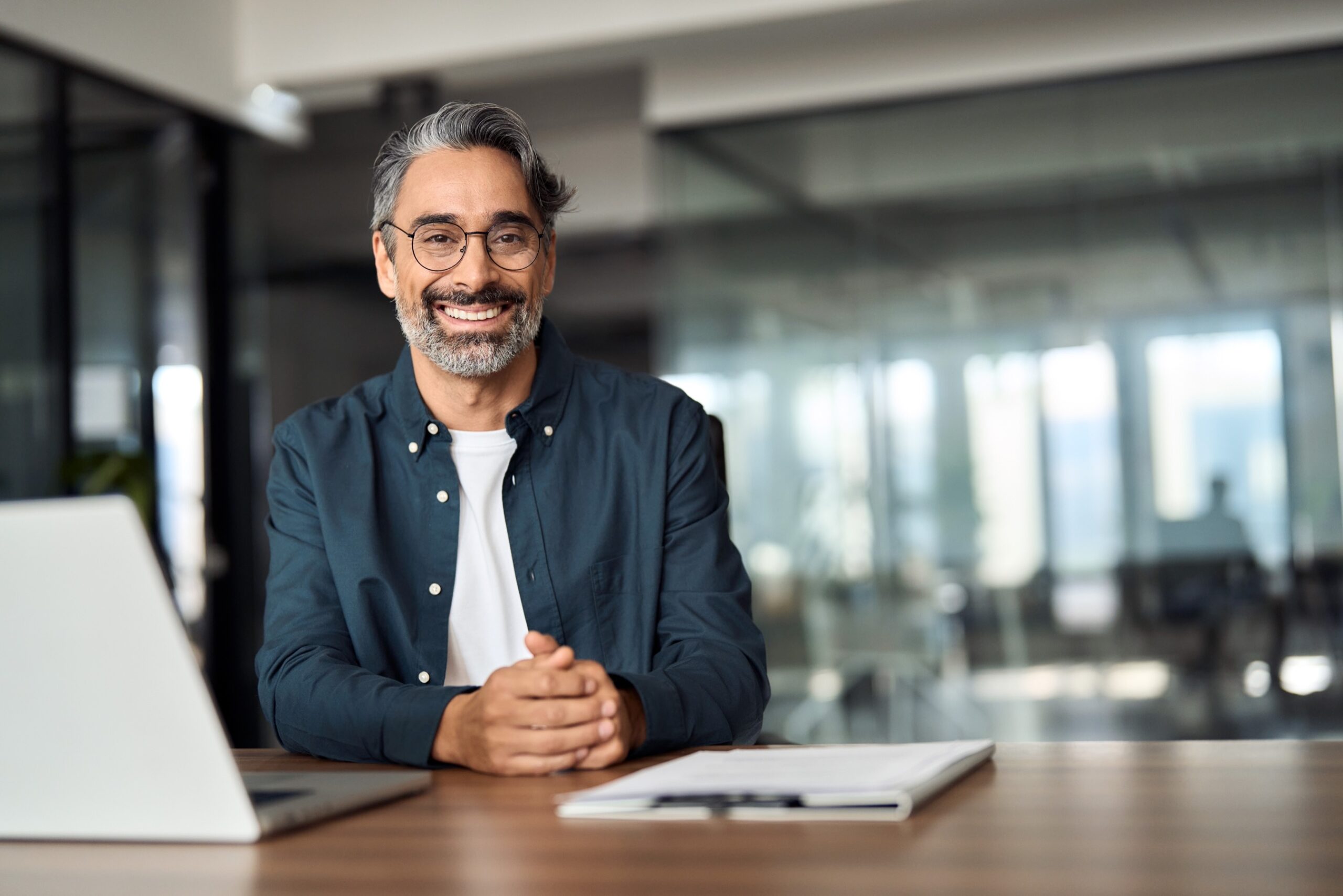 Smiling man wearing glasses while working at a desk