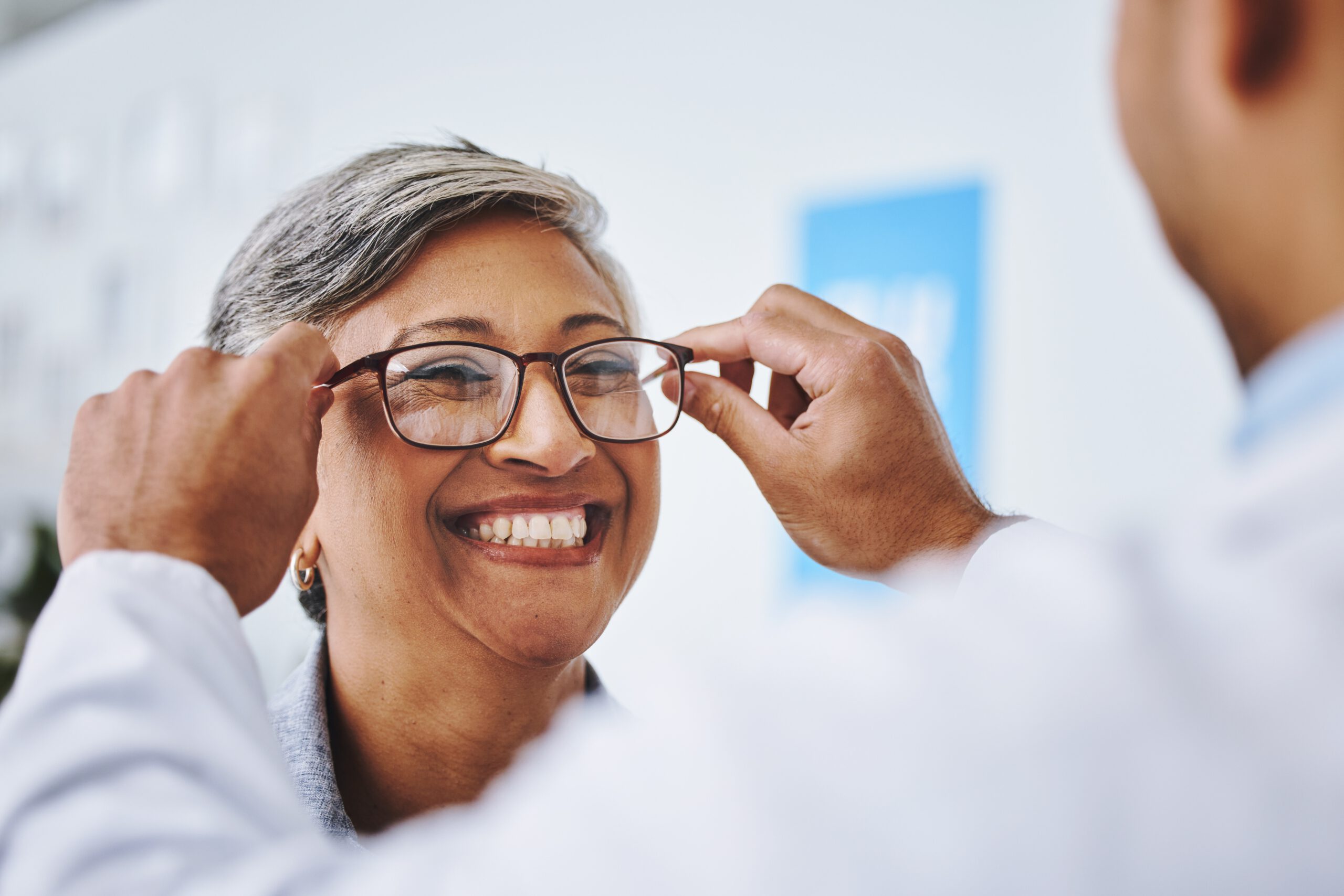 Optician helping a woman choose prescription glasses