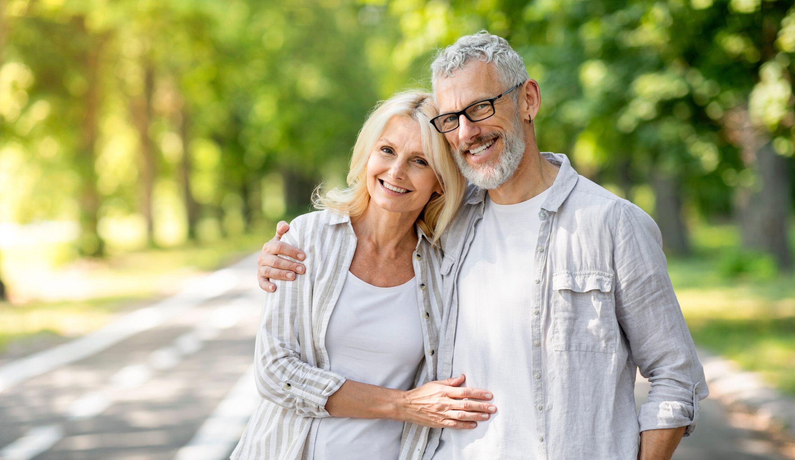 Happy senior couple embracing in a sunny park