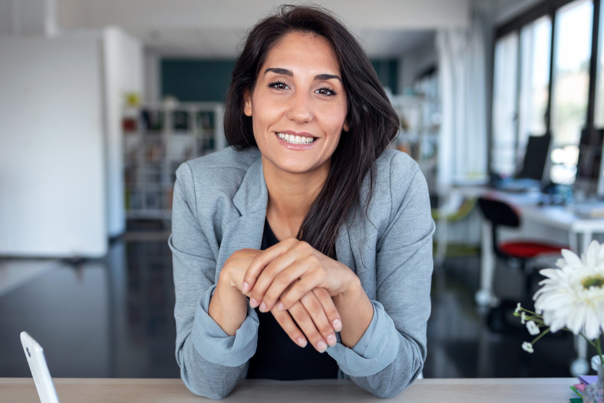 Smiling woman sitting at a desk in a bright office